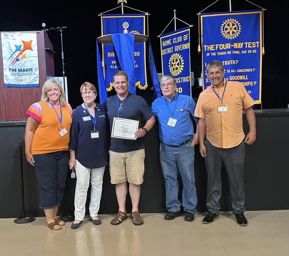 Arlington Sunrise Rotarians pose with a certificate of recognition at a district event