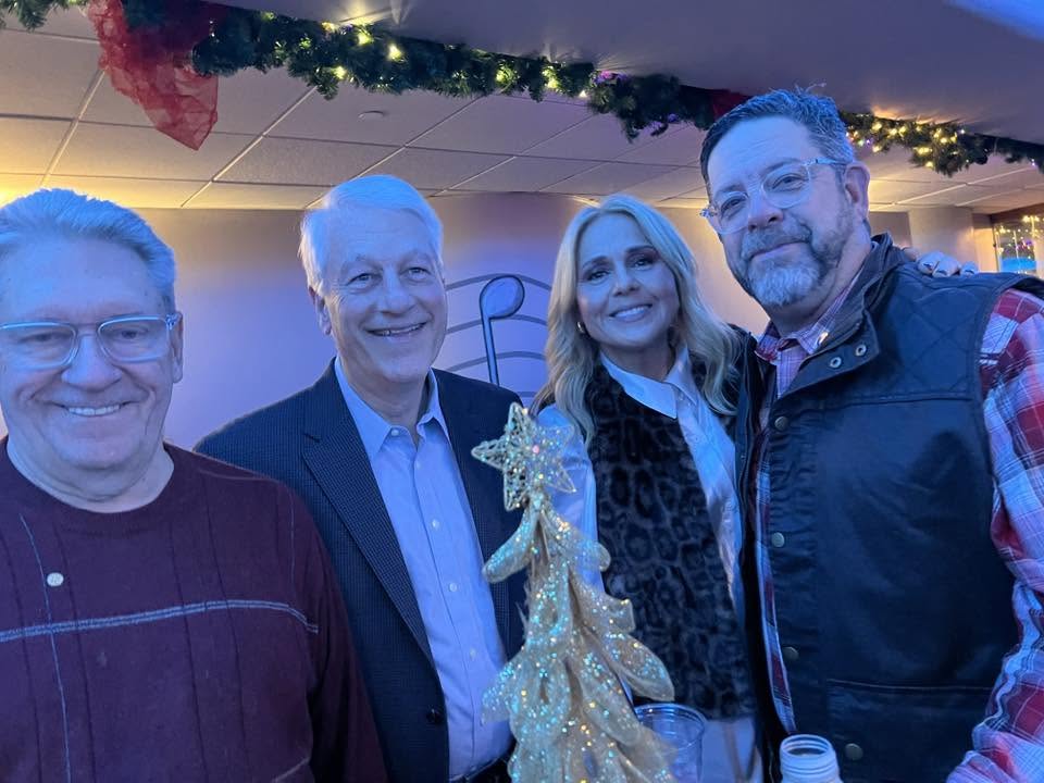 Arlington Sunrise Rotarians and guests gather by a holiday tree at the club holiday party