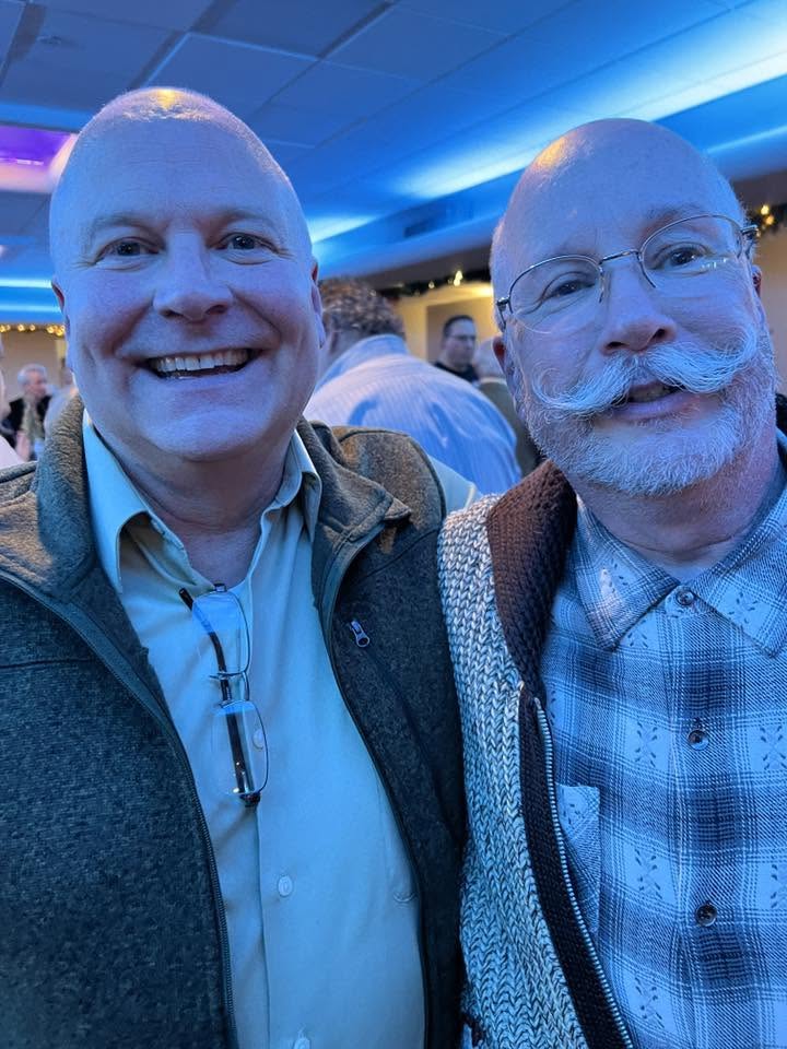 Two Arlington Sunrise Rotarians share a laugh at the holiday party