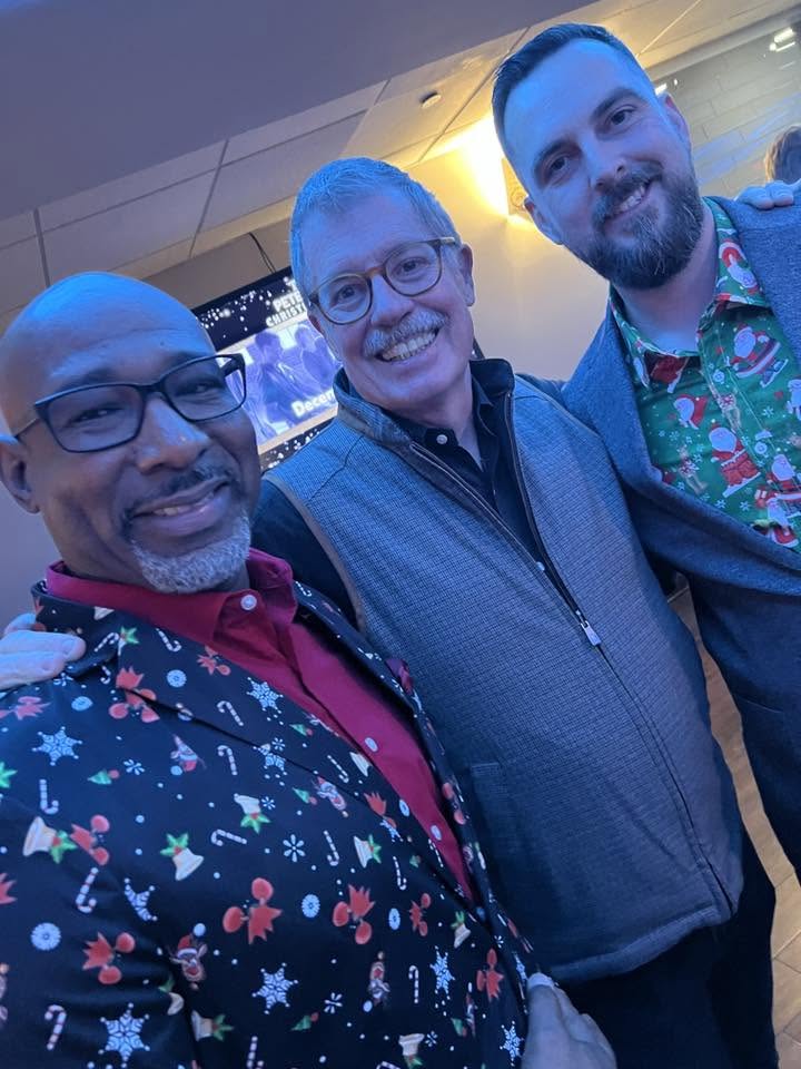 Arlington Sunrise Rotarians in festive shirts pose for a selfie at the holiday party