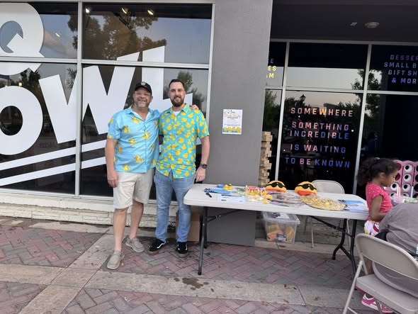 Arlington Sunrise Rotarians staff a table outside a local business during a community event