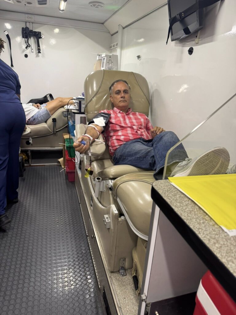 A donor gives blood aboard the Carter BloodCare bus at the Sunrise Rotary blood drive